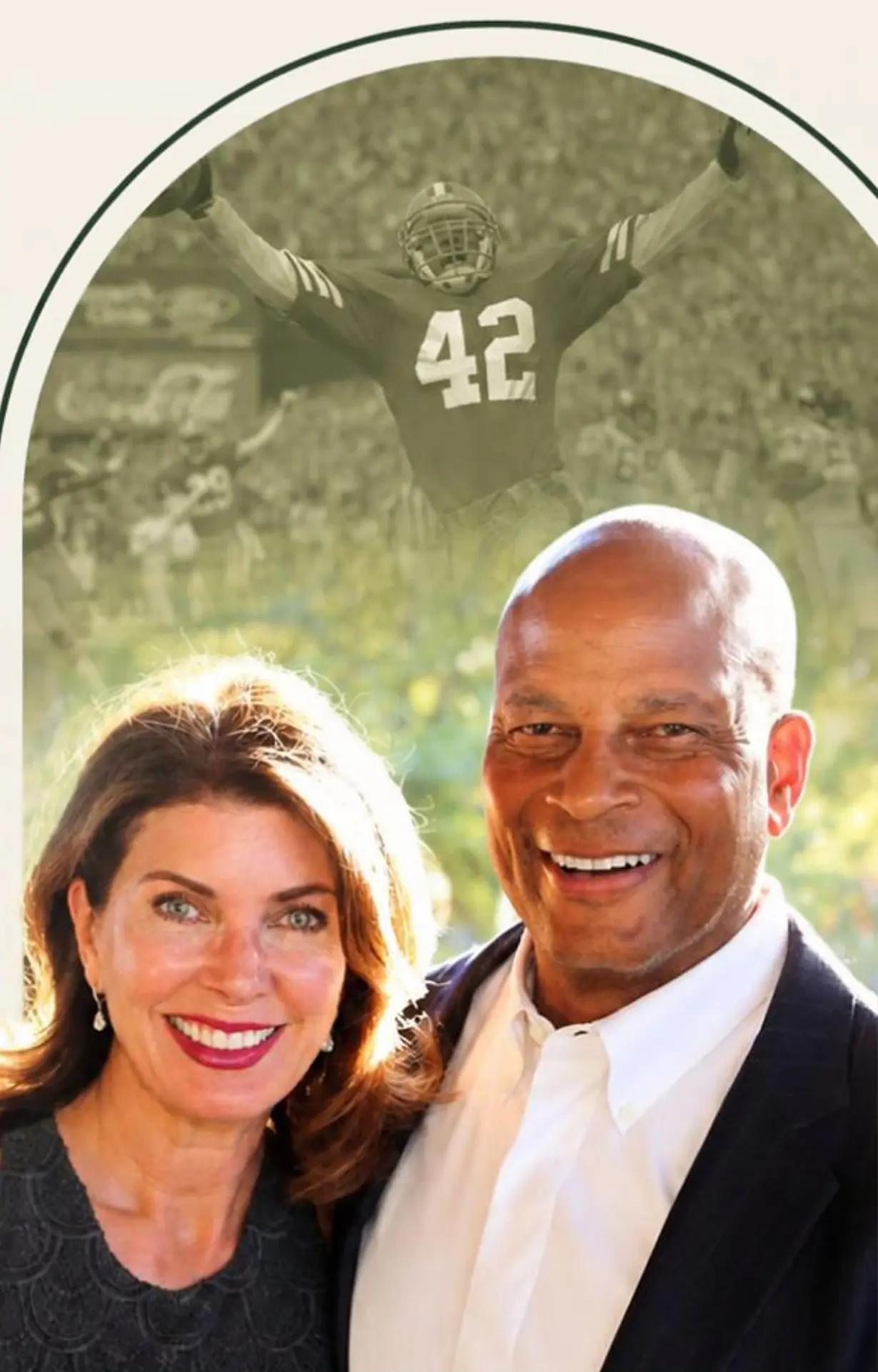 Ronnie and Karen Lott beneath an archival photo of Ronnie celebrating in his number 42 jersey
